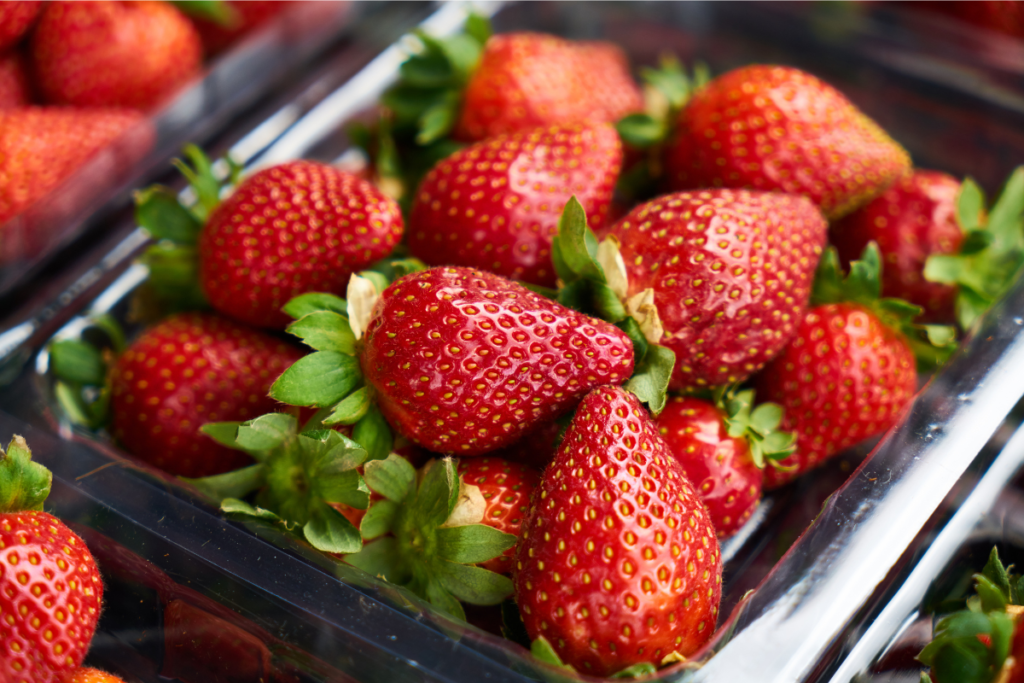 Fresh strawberries being rinsed under running water