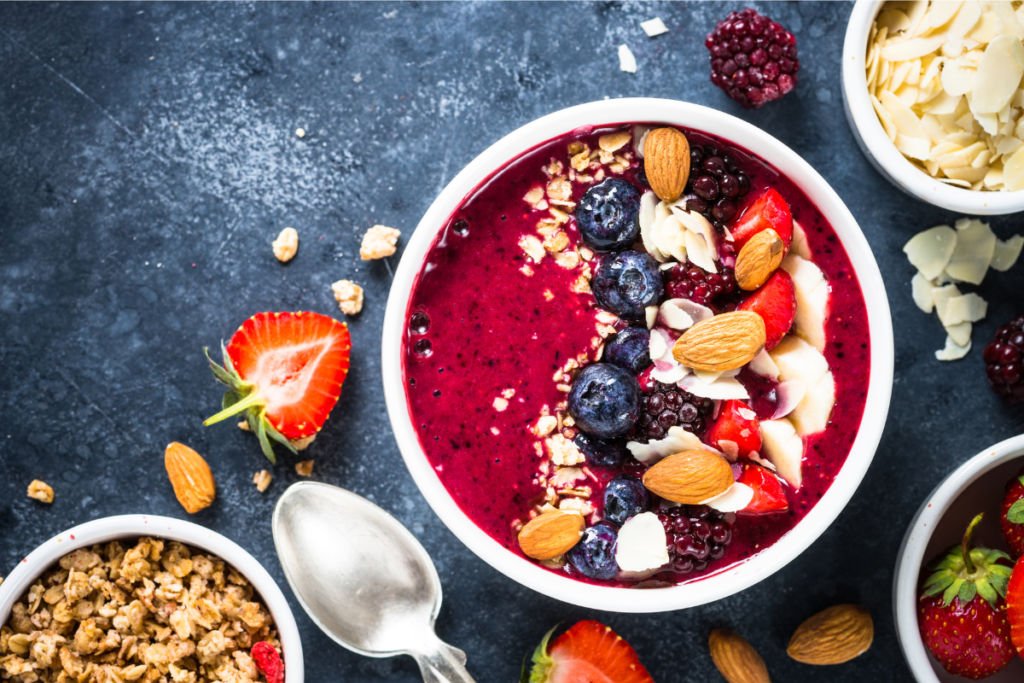 Smoothie bowl with strawberry purée, fresh strawberries, and granola topping.