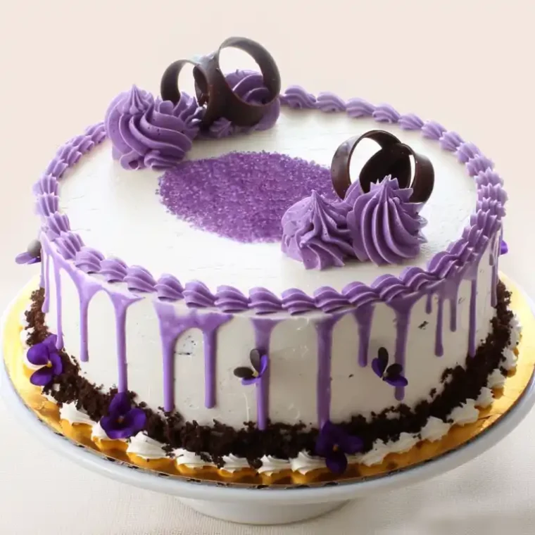 Ube Cake: The Fluffy Filipino Dessert Everyone’s Obsessed With 6 Filipino ube cakes with white frosting, purple drip icing, and chocolate decorations on rustic tables.