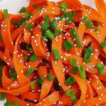 Raw Carrot Salad (5-Minute Viral TikTok Recipe!) 4 Raw carrot ribbon salad with sesame seeds and green onions, served with lime and sauces