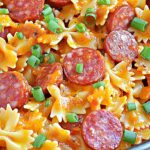 One Pot Kielbasa Pasta – Quick, Cheesy & Family-Loved Dinner 5 Cheesy one pot kielbasa pasta with bowtie noodles and green onion garnish in a skillet