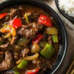 Crockpot Pepper Steak Recipe: The Ultimate Slow Cooker Comfort Dinner 4 Crockpot pepper steak with bell peppers and onions in a black bowl, served with white rice and chopsticks