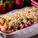Rhubarb Breakfast Cake: Moist, Golden & Perfectly Tart 3 Rhubarb breakfast cake in a loaf pan with strawberries and crumb topping