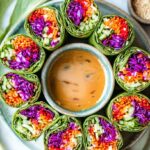 Vegetable Spring Rolls with Creamy Peanut Sauce 6 vegetable spring rolls served with peanut dipping sauce on a marble surface