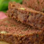 Zucchini Bread: Moist, Spiced, and Absolutely Irresistible 5 Sliced zucchini bread with nuts on a wooden board,